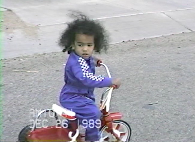 An image of Seán at one year old, riding a small red tricycle received for Christmas